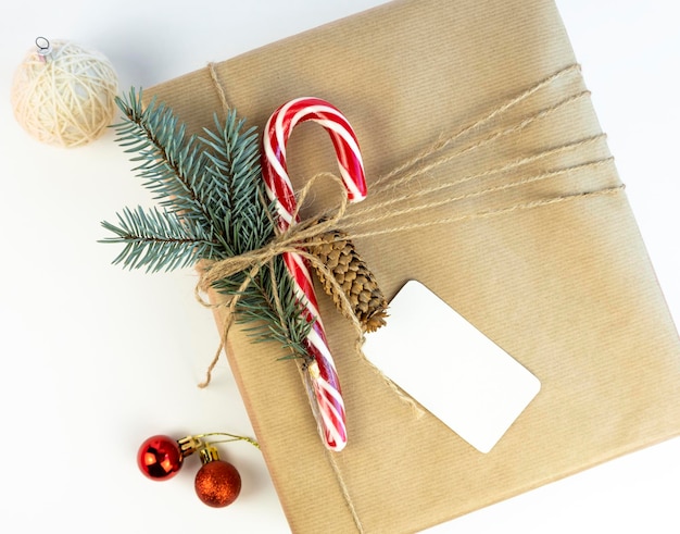 Caixa de presente de Natal ou Ano Novo com cone de galho de árvore de Natal e pirulito de Natal em fundo branco