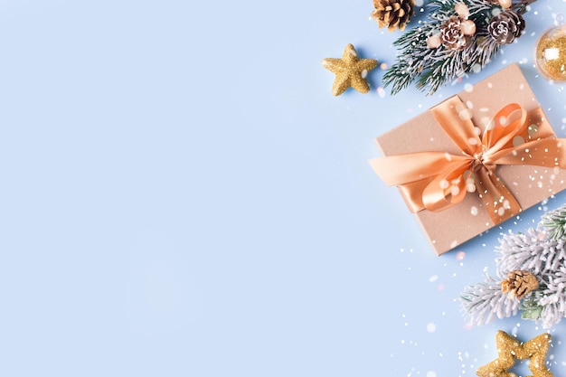 Caixa de presente de Natal plana sobre fundo azul com abeto de bola e cone Feliz ano novo espaço de cópia de fundo