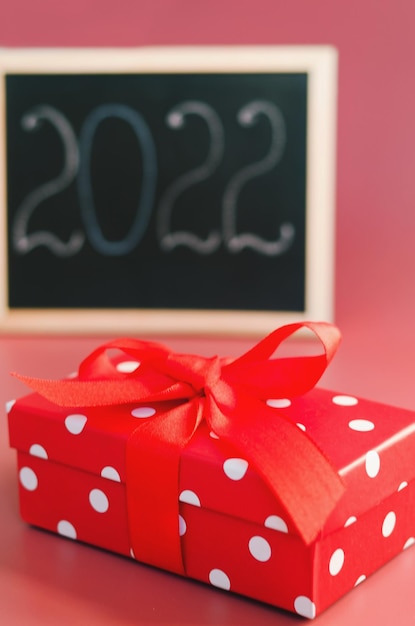 Caixa de presente de Natal vermelha e números 2022 em um quadro de avisos Plano de resoluções, objetivos, ação, ideia