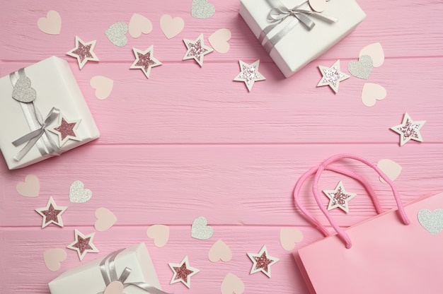 Caixa de presente de quadro com fita e confete na mesa rosa