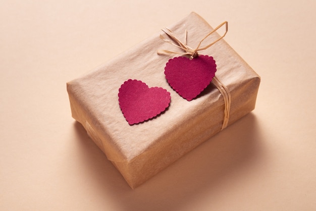 Caixa de presente decorada com duas etiquetas de coração de papel, presente de dia dos namorados