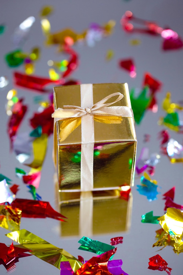 Foto caixa de presente dourada com fita de ouro, arco para o conceito de aniversário, natal, dia dos namorados, dia das mães. no fundo cinza apresentar design