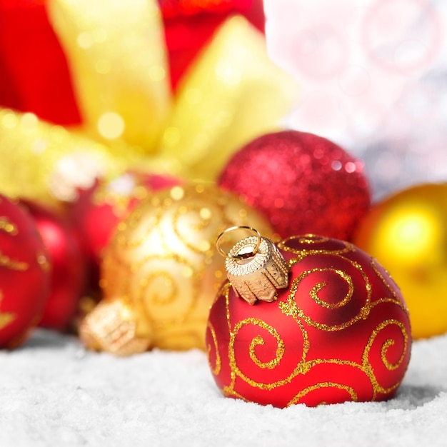 Caixa de presente e bolas de natal vermelhas na neve