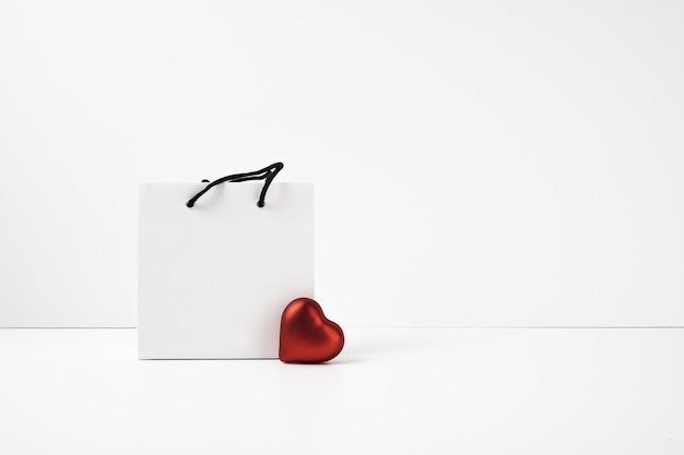 Caixa de presente e coração vermelho em branco.