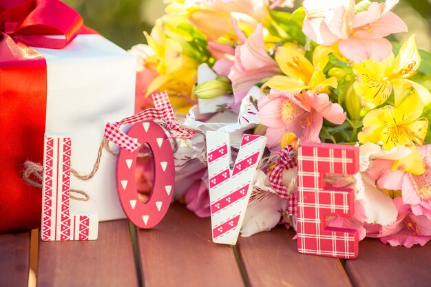 Caixa de presente e flores no contexto da primavera. conceito de férias em família. dia das mães