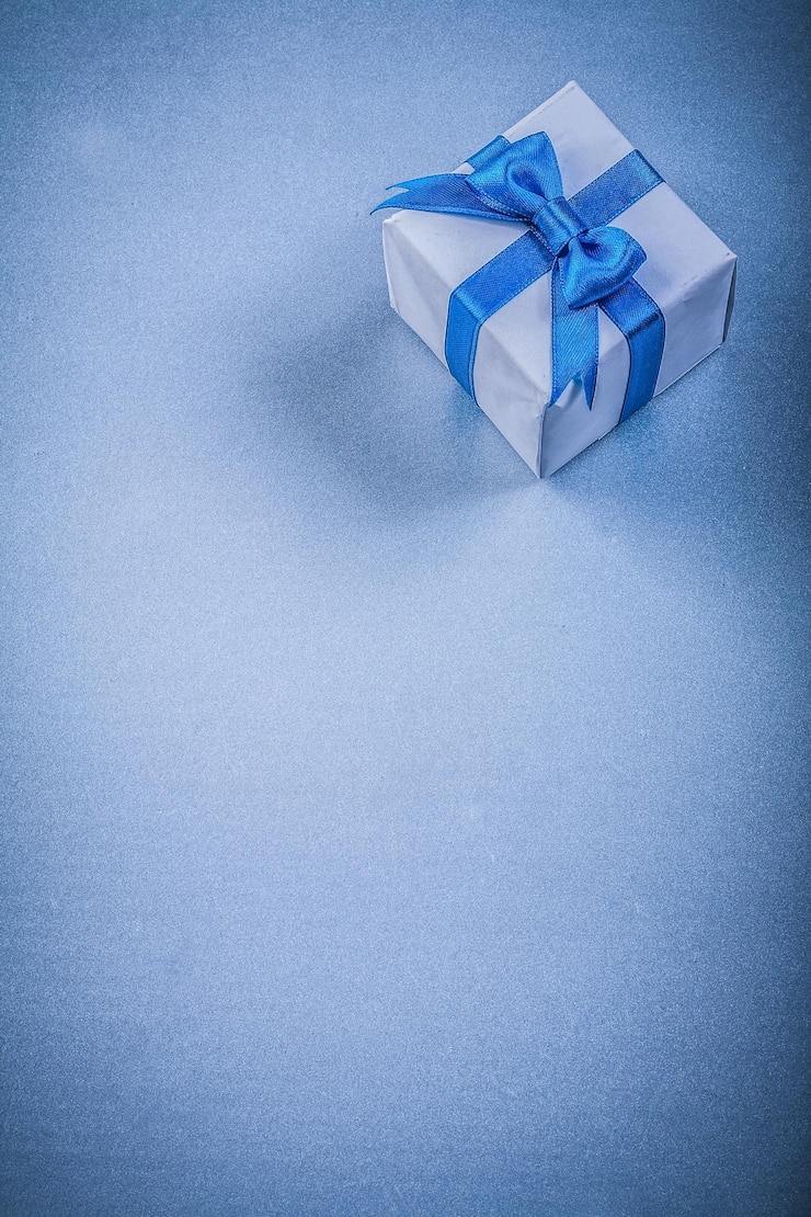 Foto caixa de presente embalada com laço no fundo azul