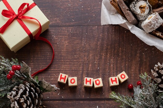 Caixa de presente festiva de Natal e doces com decorações de temporadas em fundo de madeira