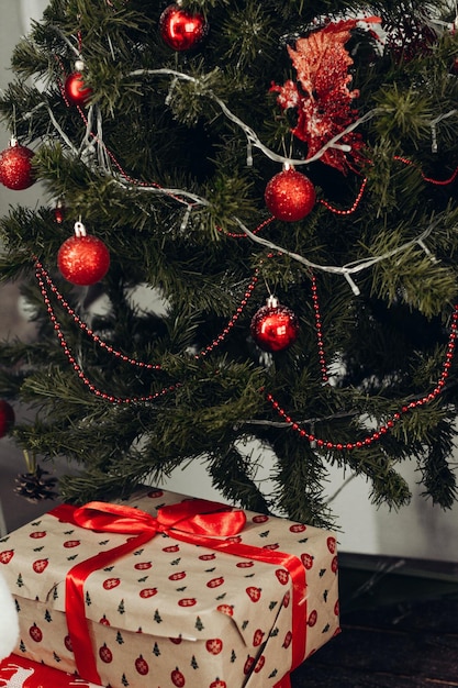 Caixa de presente marrom sob a árvore de Natal verde Foto