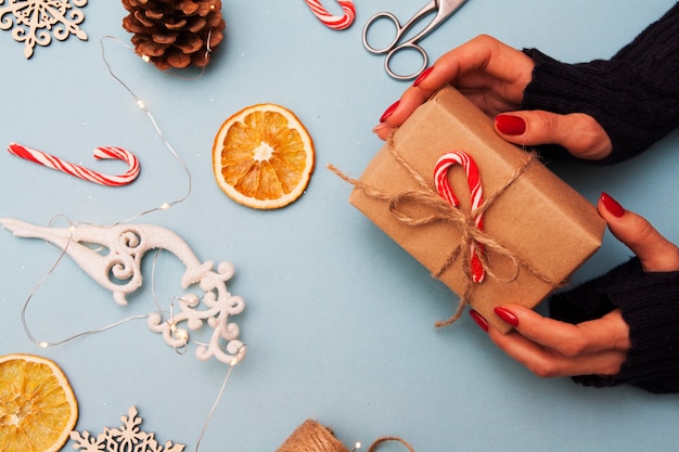 Caixa de presente nas mãos e decorações de natal