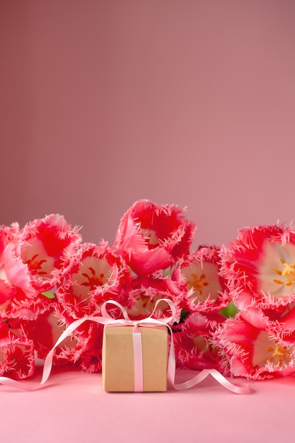 Caixa de presente ou presente com lindo buquê de flores tulipas cor de rosa na superfície rosa