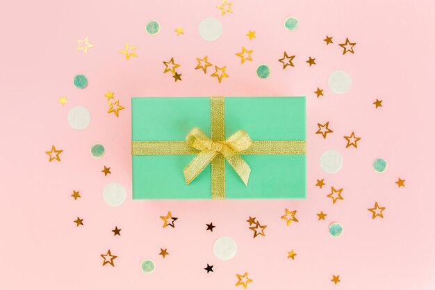 Caixa de presente ou presente e confete de estrelas em fundo rosa Celebração colorida de aniversário Natal ou Ano Novo padrão Vista superior plana