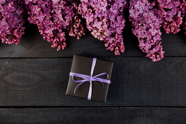 Caixa de presente pequena preta com flores lilás naturais