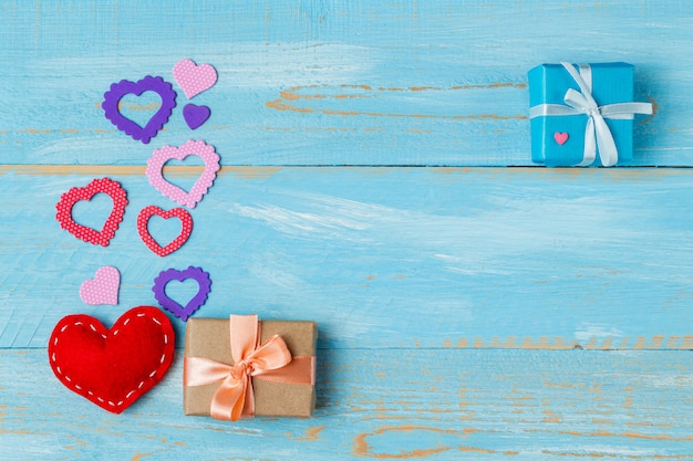 Caixa de presente presente com corações para dia dos namorados no fundo de madeira azul com espaço de cópia