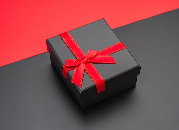 Caixa de presente preta em fundo vermelho e preto