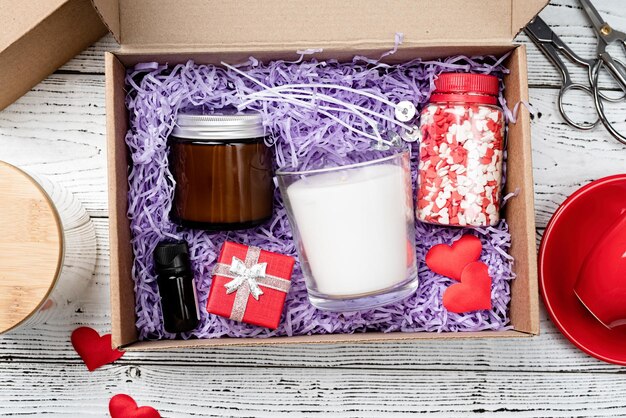 Caixa de presente sazonal para dia dos namorados com copo de vela vermelha e doces em forma de coração