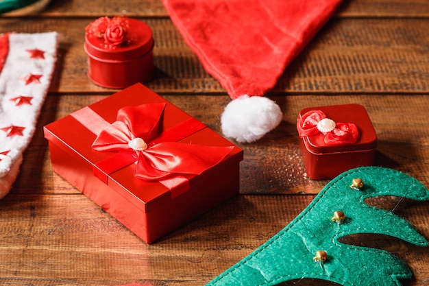 Caixa de presente vermelha e chapéu de Papai Noel na mesa de madeira