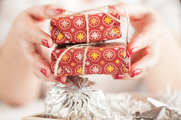 Caixa de presente vermelha nas mãos femininas. decoração de natal