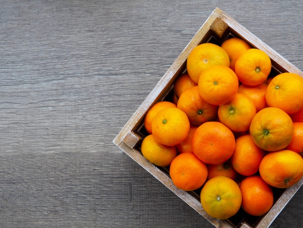 Caixa de tangerinas na mesa de madeira