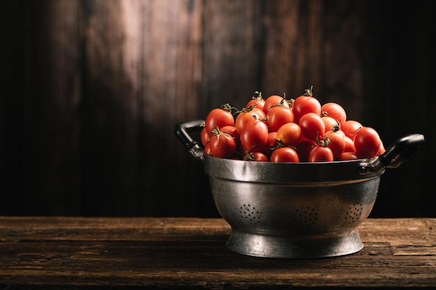 Caixa de tomates vermelhos frescos na mesa de madeira