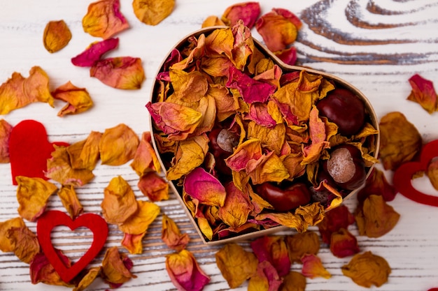 Caixa em forma de coração com pétalas secas de castanhas potpourri rosa e design de corações no dia do amor