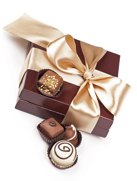 Foto caixa marrom com doces e fita dourada