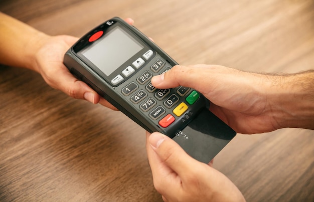Caixa oferecendo terminal POS para pagamento com cartão de crédito