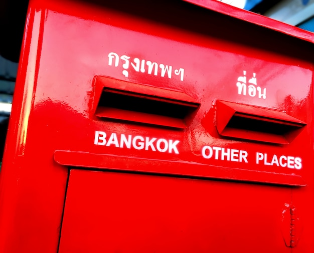 Caixa postal vermelha vívida com textos de destino em inglês e tailandês