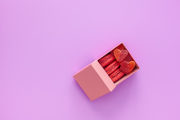 Caixa rosa com geleia e macaroons e uma linda rosa em uma mesa rosa