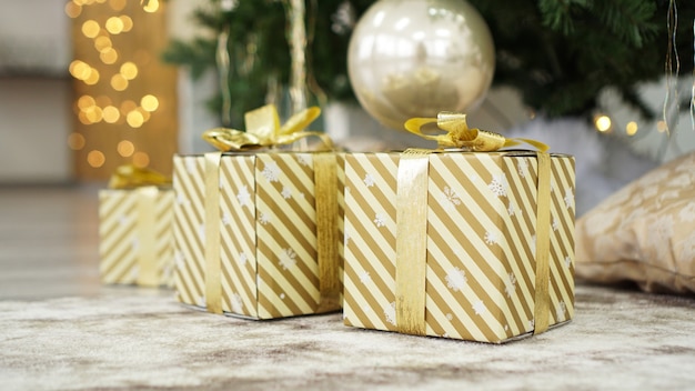 Caixas de ouro com presentes embaixo da árvore de Natal