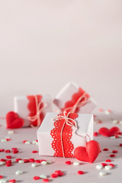 Caixas de presente de dia dos namorados com presentes e decorações. Em fundo rosa com granulado.