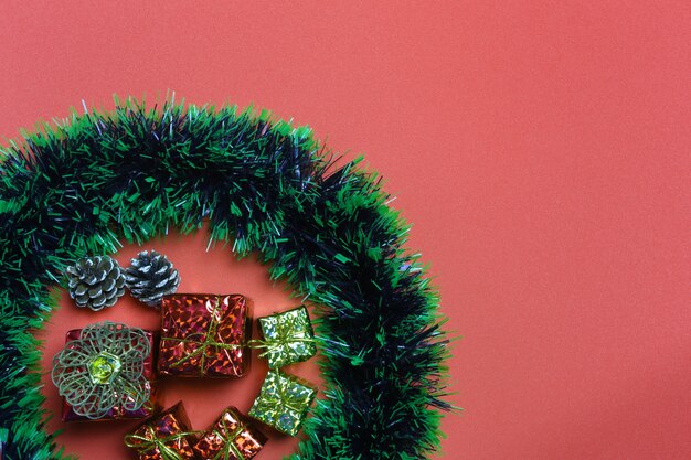 Caixas de presente de Natal e decorações em fundo de papel de arte vermelho.