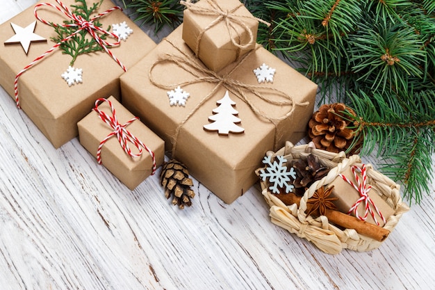 Caixas de presente de Natal e galho de árvore do abeto com cesto na mesa de madeira
