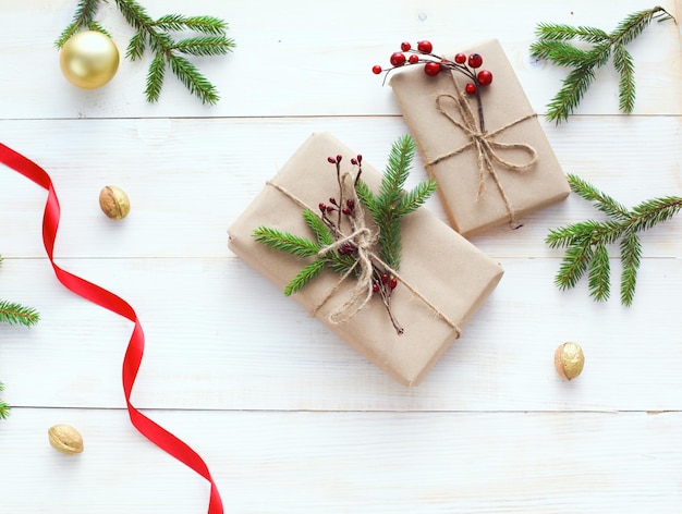 Caixas de presente de Natal e galho de árvore do abeto em mesa de madeira plana fundo de Natal