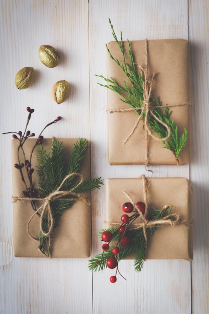 Caixas de presente de natal e galho de árvore do abeto em mesa de madeira plana fundo de natal