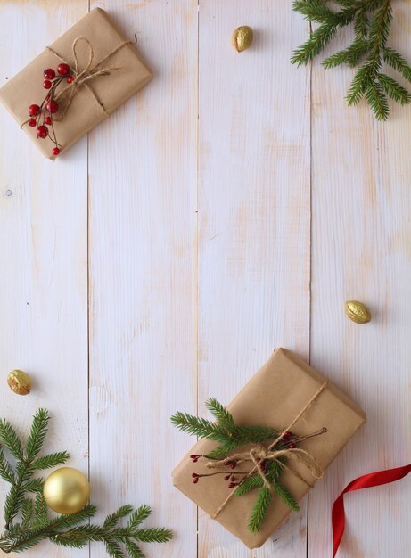 Caixas de presente de Natal e galho de árvore do abeto em mesa de madeira plana fundo de Natal