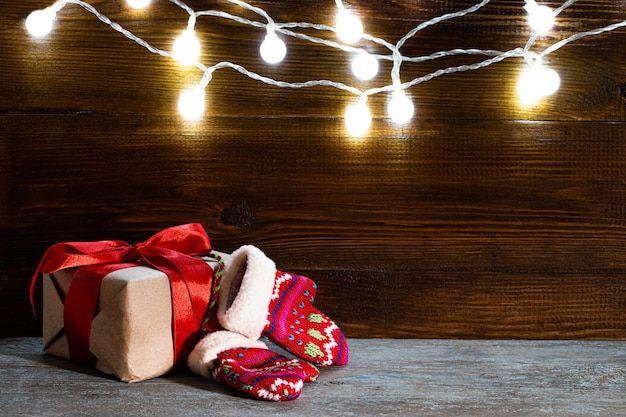 Caixas de presente de Natal e luzes sobre fundo de madeira, copie o espaço.