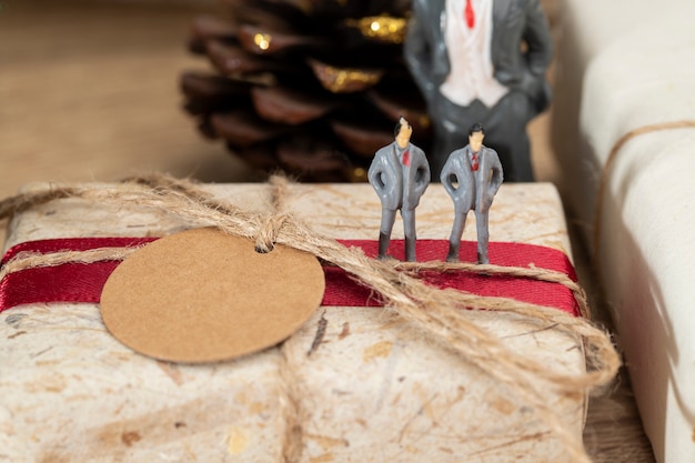 Caixas de presente de Natal marrom e fita vermelha com papel etiqueta colocam sobre a mesa, vista frontal com espaço de cópia.