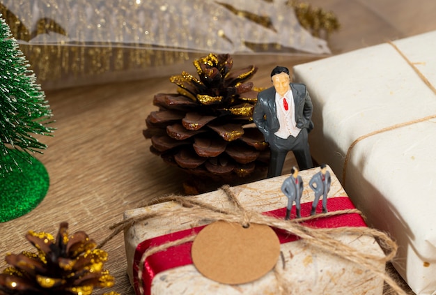 Caixas de presente de Natal marrom e fita vermelha com papel etiqueta colocam sobre a mesa, vista frontal com espaço de cópia.