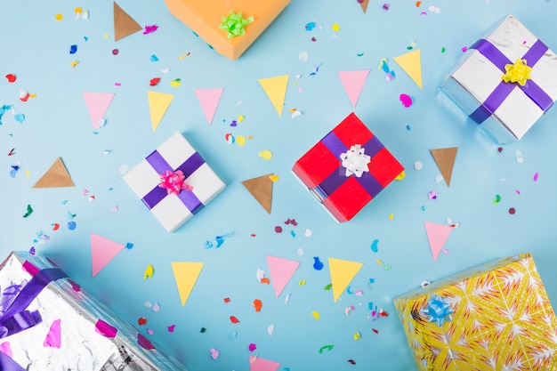 Caixas de presente decorativo com bandeira de estamenha e confetes sobre o fundo azul