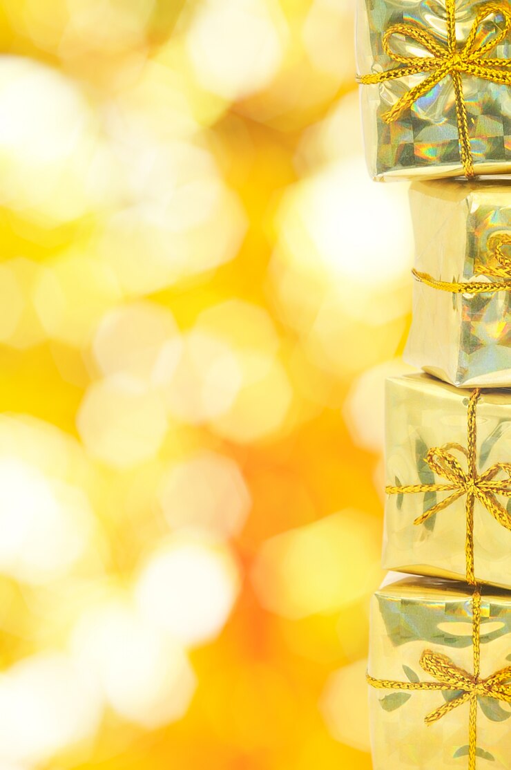Foto caixas de presente dourado sobre fundo amarelo bokeh