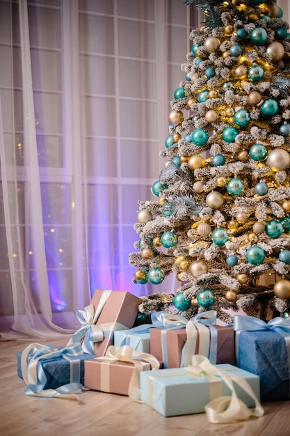 Caixas de presente embaixo da árvore de Natal, decorações de Natal para a casa, papel de embrulho de Papai Noel para presentes, árvore de Natal decorada com uma guirlanda