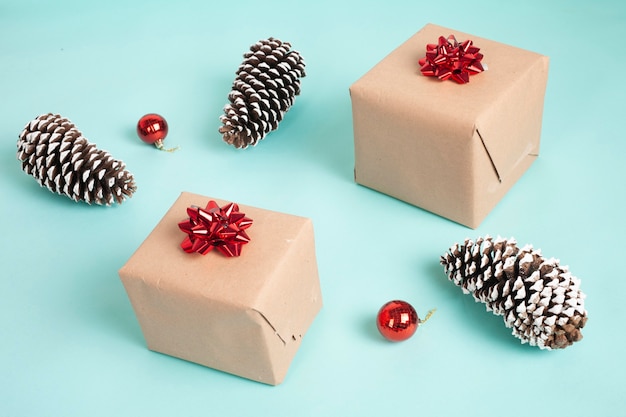 caixas de presente embrulhadas em papel kraft e amarradas com um laço vermelho de natal em um fundo azul