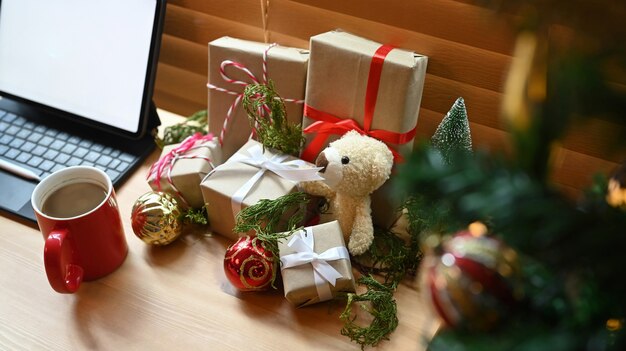 Caixas de presente, enfeites de natal e decorações de ursinho de pelúcia na mesa de madeira.