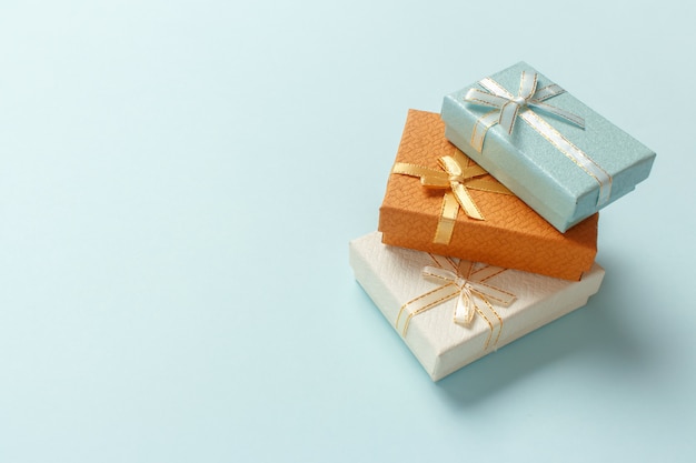 Caixas de presente pequenas são empilhadas em um fundo turquesa pastel. Presentes de Natal.