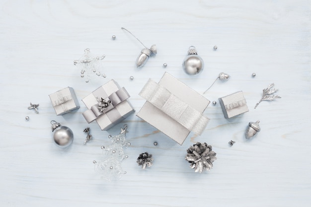 Caixas de presente prateadas e decorações de natal na mesa azul claro