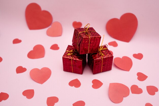 Caixas de presente vermelhas e corações vermelhos em uma rosa