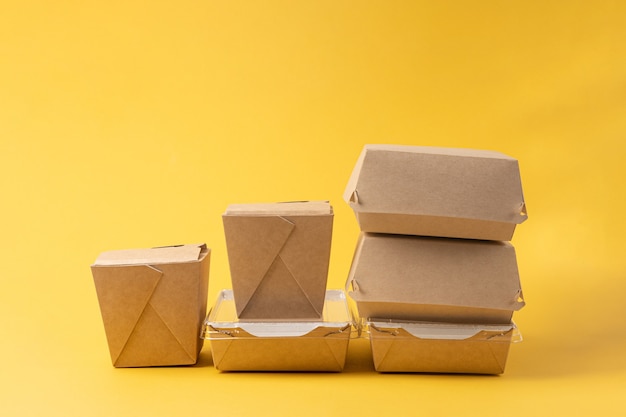 Caixas descartáveis de entrega de comida em fundo amarelo