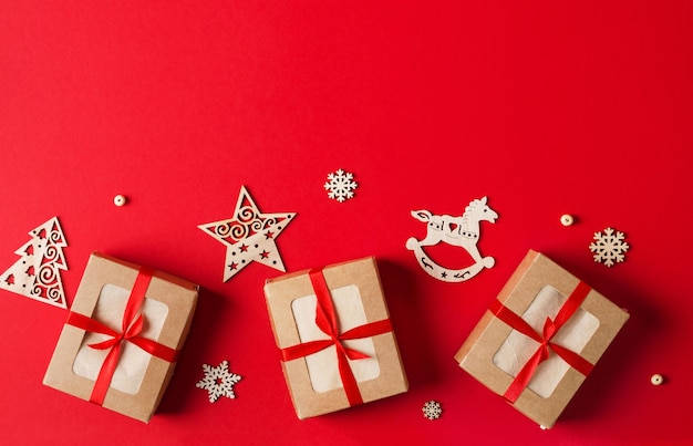 Caixas eco de presentes de Natal com fita de cetim vermelha em fundo vermelho e zero brinquedos para árvores de Natal