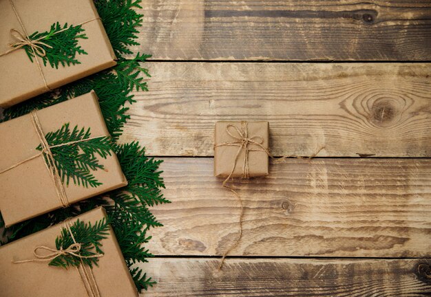 Caixas embaladas com papel kraft sobre fundo de madeira. Material ecológico. Artesanato artesanal. Natal e ano novo.