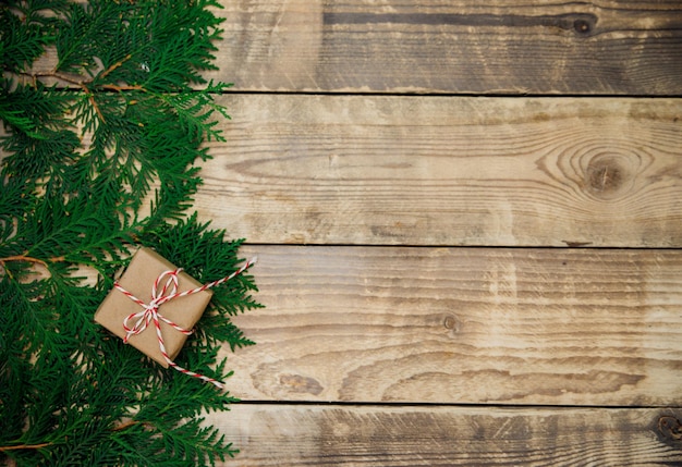 Caixas embaladas em papel kraft e galhos verdes sobre fundo de madeira. Natal e ano novo.
